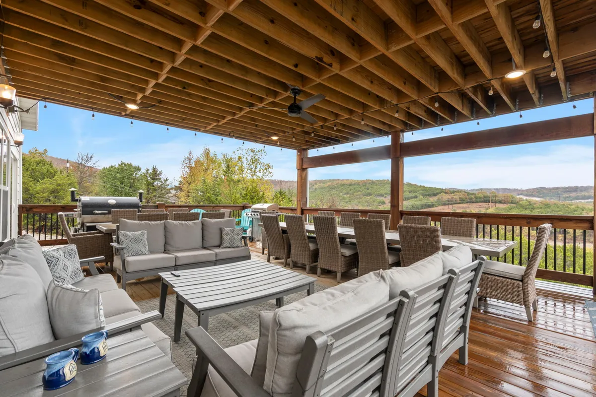 An outdoor dining space with a comfortable seating area, large table, and a visible grill creates an inviting atmosphere for al fresco meals and barbecues. The scene suggests a seamless transition from the kitchen to outdoor entertaining, which is central to the Chef’s Social Domain.